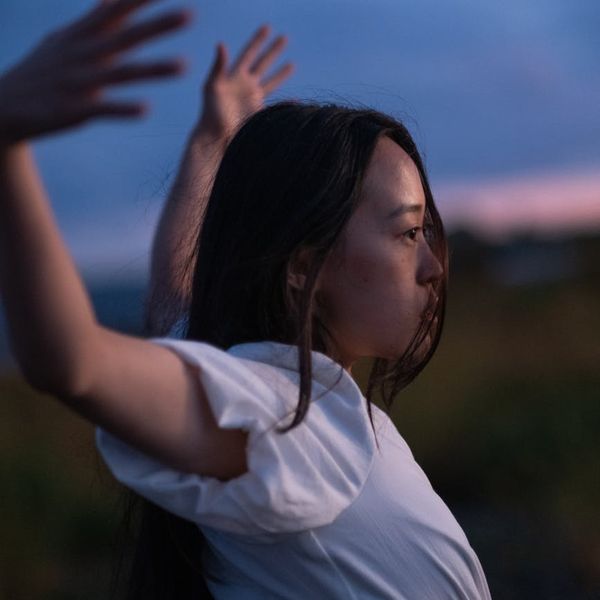Person stretching outdoors with a serene natural background.
